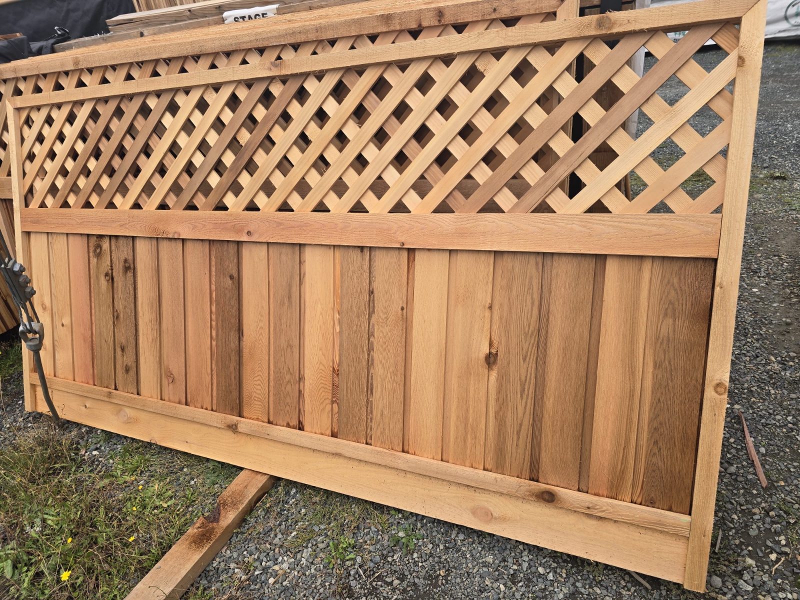 Cedar fence panel with solid boards and a diagonal lattice top, in the yard